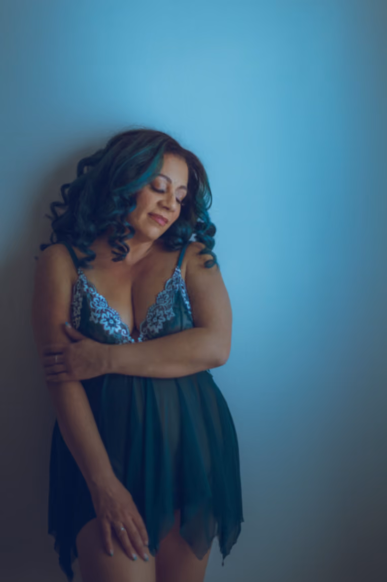 Smiling woman with curly hair in a sheer green babydoll
